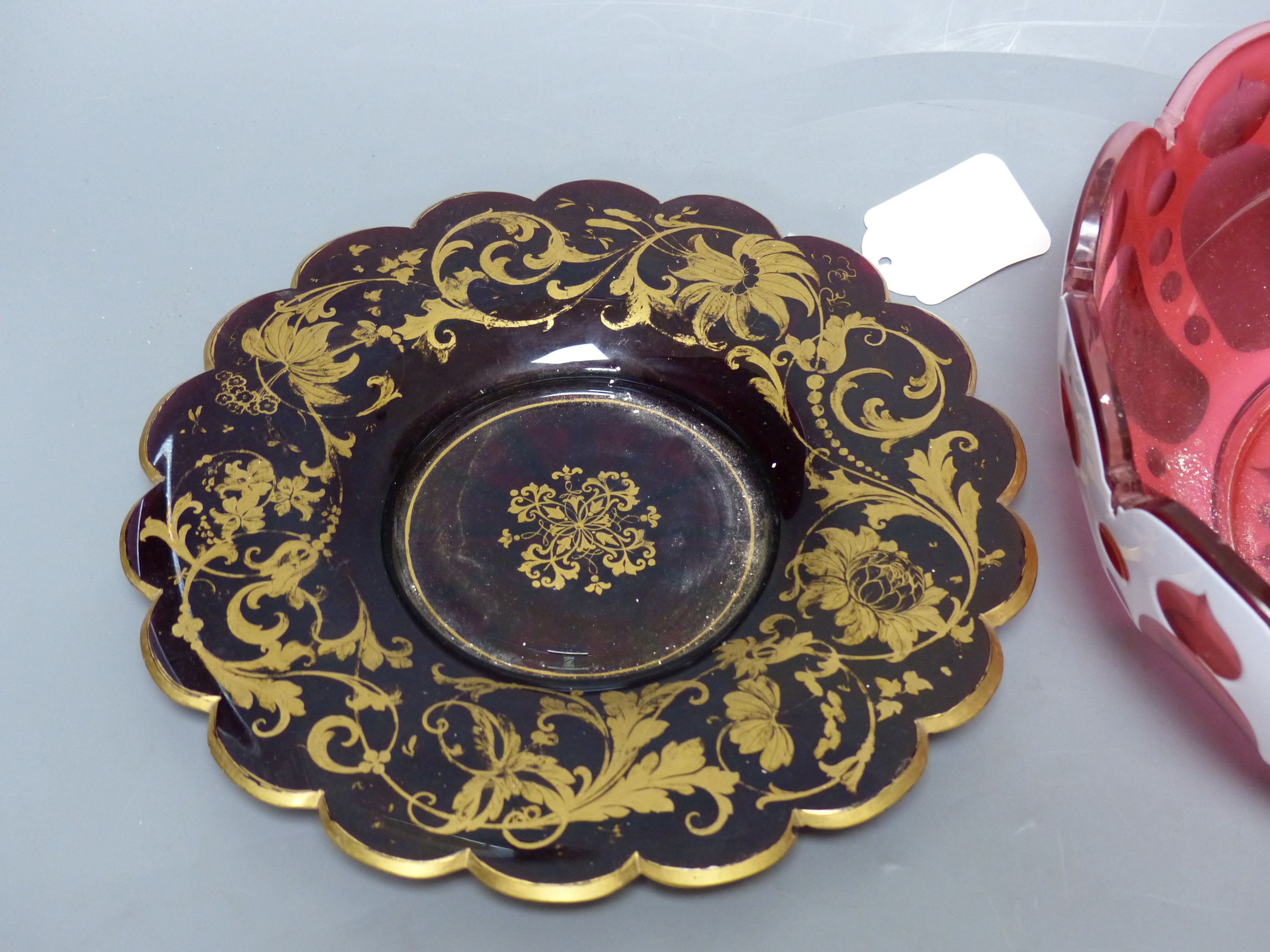 A Bohemian cranberry and white overlay glass circular bowl, a similar conical turquoise bowl and a gilded ruby glass dish
